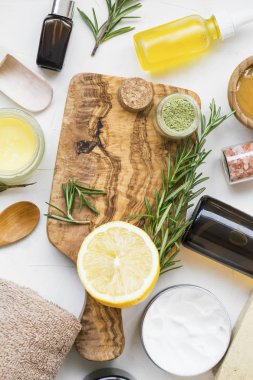 Spa natürmort organik maddeler, doğal sabun, kil, esans, biberiye bitki, limon ve banyo tuzu ahşap tahta üzerinde cilt bakım tedavileri ve maskeleri için organik madde üstten görünüm