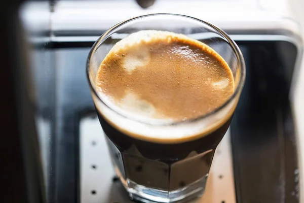 Espresso double cup freshly made on coffee machine closeup with creamy froth, hot brown aroma coffee cup