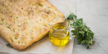 Focaccia bread with olive oil and oregano herb, freshly baked italian bread with mediterranean ingredients clipart