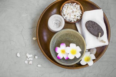 Spa Ürünleri ahşap tepsi, frangipani çiçekli spa öğelerin en iyi görünümü içinde mum, tuz, banyo havlusu ve taş, spa natürmort ayarlama ponce
