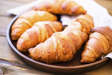 Taze croisssants buns yığın içinde ahşap tepsi, Fransız kruvasan, f
