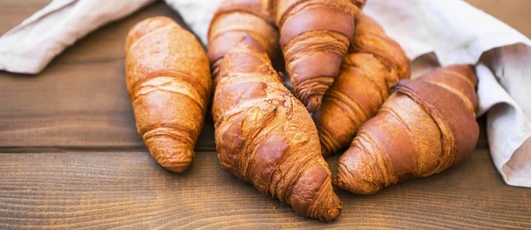 Ψωμάκια φρέσκο croisssants στο ξύλινο τραπέζι, Γαλλικά κρουασάν, φρέσκα — Φωτογραφία Αρχείου