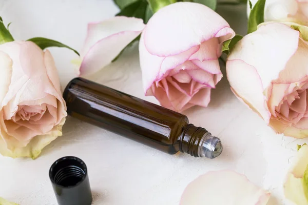 Rose oil in roll on bottle, rose flowers perfume — Stock Photo, Image