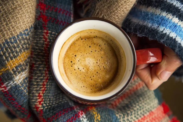 Cozy cair xícara de café vista superior, as mãos da mulher segurando quente rústico a — Fotografia de Stock