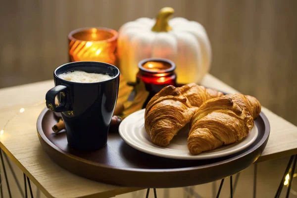 Cozy autumn morning breakfast with coffee cup, croissants and ca