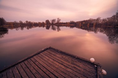 Dramatik sonbahar Gölü yansıması. Ahşap iskele günbatımı Gölü'nden görüntülemek