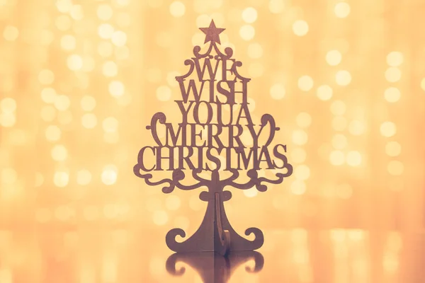 Merry Christmas sign in wooden Christmas tree. Winter holiday background, greeting card template