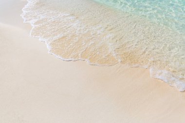 Tropikal plaj, kum ve rahatlatıcı yumuşak dalgalar closeup plaj. İlham verici su ve deniz kavramı