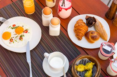 Sağlıklı kahvaltı. Kahve, portakal suyu, kruvasan, yumurta, sebze ve kruvasanla kahvaltı.