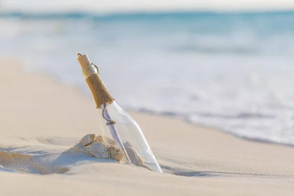 Message in the bottle washed ashore against the sun setting down. Tropical beach design background, message in the bottle washed ashore against the Sun setting down