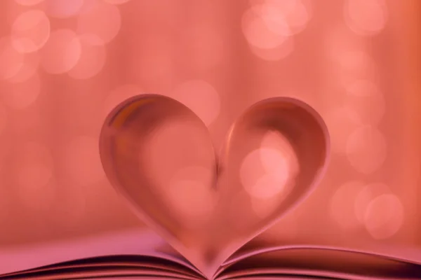 Heart from a book page romantic style close up heart shape from paper book with bokeh in soft light at night, blur background, copy space, concept for valentine\'s day and couple love background