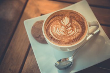 Kahve dükkanında sütlü kahve, yumuşak doğal ışık.