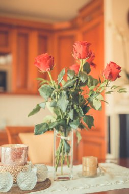Evdeki masada güzel bir buket kırmızı gül çiçeği, antika filtre.