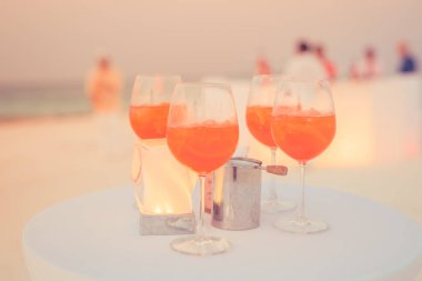 Plaj partisinde aperol spreyli kokteyller ve arka planda bulanık insanlar vardı. Sığ odak içinde sosyal etkinlik karamsar afiş tasarımı