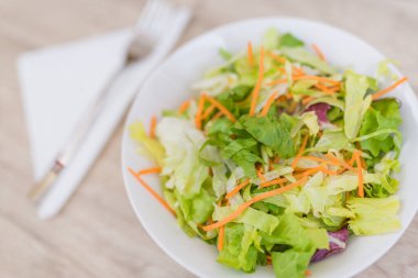 Vejetaryen diyeti kavramı. Farklı salatalardan taze yapraklar. Eski ahşap masada taze sebze salatası, vegan yemeği.