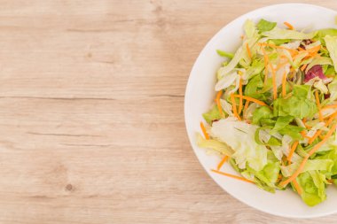Vejetaryen diyeti kavramı. Farklı salatalardan taze yapraklar. Eski ahşap masada taze sebze salatası, vegan yemeği.