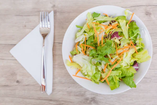 Vejetaryen diyeti kavramı. Farklı salatalardan taze yapraklar. Eski ahşap masada taze sebze salatası, vegan yemeği.