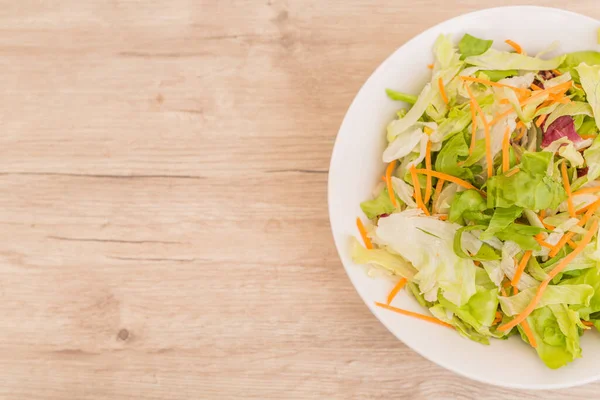 Vejetaryen diyeti kavramı. Farklı salatalardan taze yapraklar. Eski ahşap masada taze sebze salatası, vegan yemeği.