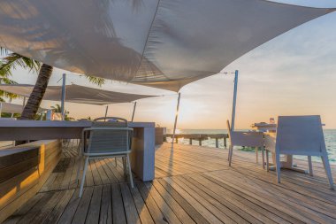 Lüks yemekler beyaz masada, güzel tropikal deniz manzaralı arka plan, gün batımı yaz tatili ve romantik tatil konsepti, lüks seyahat ve yaşam tarzı