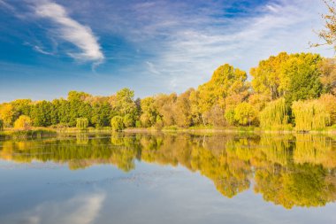 Su yansıtmalı Idyllic sonbahar gölü manzarası. Mükemmel sonbahar ağacı yansımaları, mevsimsel doğa manzarası, sakin su ve mavi gökyüzü.