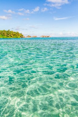 Deniz lagünüyle dolu su bungalovlarının üzerinde. Güzel tropikal Maldivler tatil için gökyüzünde plaj ve deniz bulunan otel ve adalara, egzotik gezilere giderler.. 