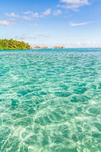 Deniz lagünüyle dolu su bungalovlarının üzerinde. Güzel tropikal Maldivler tatil için gökyüzünde plaj ve deniz bulunan otel ve adalara, egzotik gezilere giderler.. 
