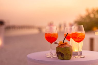 Aperol spreyli kokteyl içeceği, seçici odaklanma ve detaylar. Tropik plajda alkollü içecek. Plaj partisinde aperol spreyli kokteyller ve arka planda bulanık insanlar vardı. Sığ odak içinde sosyal etkinlik karamsar afiş tasarımı