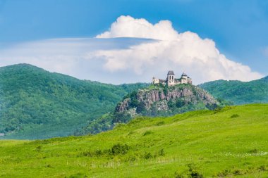 Mavi gökyüzü ve bulutların altında eski şato kalıntıları ve dağ arka planı. Macaristan, Fuzer Castle. Avrupa Mirası Alanı