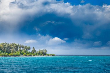 Okyanustaki güzel yeşil ada. Tropik tropik plajlar Hindistan cevizi palmiyeleri, sakin dalgalar, bulutlu gökyüzü