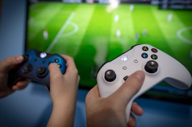 Debrecen, Macaristan, Marc 11. Xbox 1 'in oyun sahası, oyun konsolu, elinde tutan çocuk. Bulanık arka plan görüntüsü ve oyun konsepti. Fifa Dünya Kupası konsept tasarımı, E-futbol