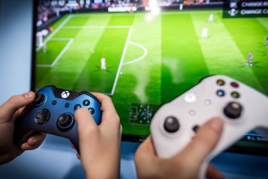 Debrecen, Macaristan, Marc 11. Xbox 1 'in oyun sahası, oyun konsolu, elinde tutan çocuk. Bulanık arka plan görüntüsü ve oyun konsepti. Fifa Dünya Kupası konsept tasarımı, E-futbol