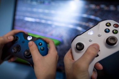 Debrecen, Macaristan, Marc 11. Xbox 1 'in oyun sahası, oyun konsolu, elinde tutan çocuk. Bulanık arka plan görüntüsü ve oyun konsepti. Fifa Dünya Kupası konsept tasarımı, E-futbol