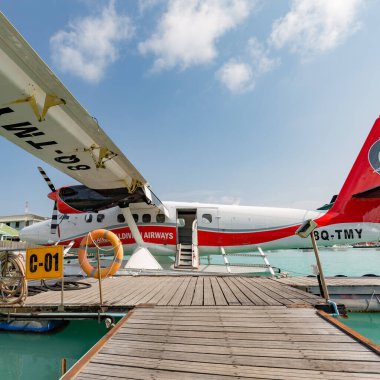 Erkek, Maldivler 10 Mayıs 2019: TMA - Maldivler 'deki MLE havaalanında Trans Maldivian Airways Twin Otter deniz uçakları. Yüzen ahşap iskelenin yanına deniz uçağı parkı, Maldivler