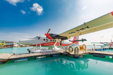 Erkek, Maldivler 10 Mayıs 2019: TMA - Maldivler 'deki MLE havaalanında Trans Maldivian Airways Twin Otter deniz uçakları. Yüzen ahşap iskelenin yanına deniz uçağı parkı, Maldivler