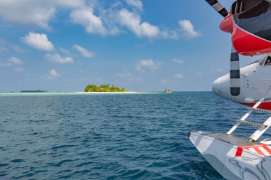 Tropikal sahil beldesinde deniz uçağı. Maldivler lüks oteldeki deniz uçakları, ahşap iskeleler uçağa yükleniyor, kalkışa hazır. Maldivler adasında tropik ada geçmişi, seyahat ve turizm kavramı