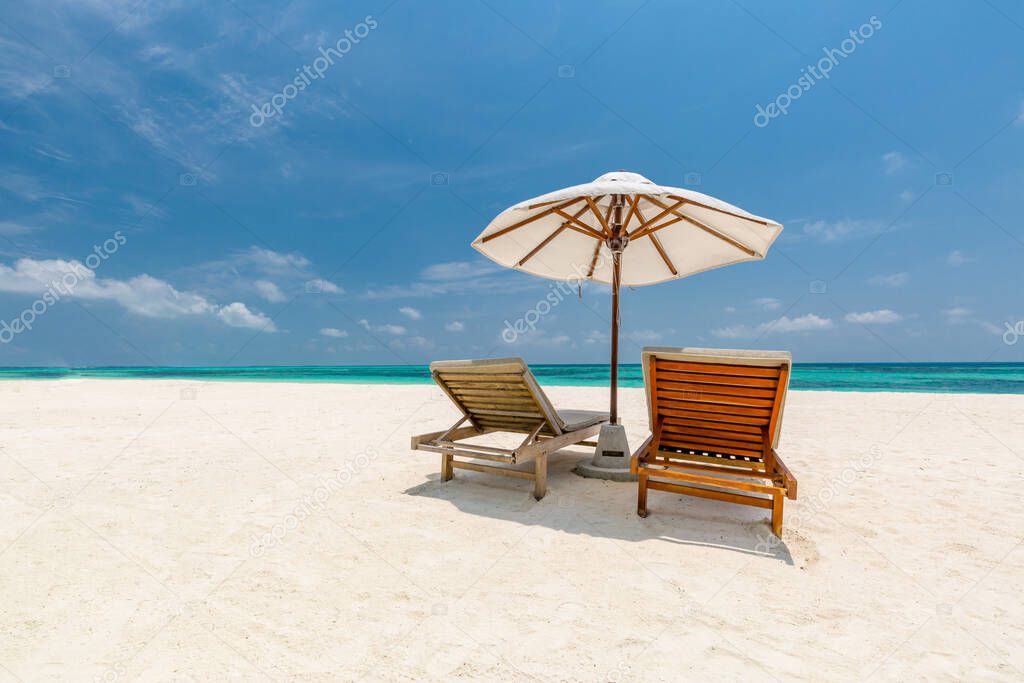 Perfect beach vacation landscape. Sea sand sky concept with umbrella and loungers or beach chairs. Luxury  summer holiday scenery, exotic destination background with copy space for text. Summer beach, sunny sea shore couple honeymoon romantic getaway