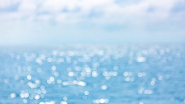 Yaz mevsimi için deniz ve okyanus arka planındaki soyut bulanık ışık. Nehirdeki mavi suyun yansımasının bulanık arka planı. Bokeh ana nesne gibi. Duvar kağıdı ya da kartpostal