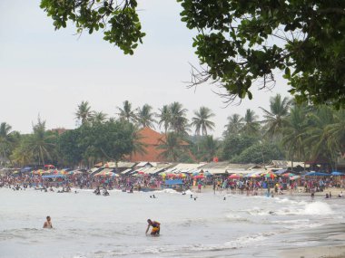 Anyer, Endonezya - 24 Haziran 2018: Kalabalık insan faaliyetleri Sambolo Plajı'nda yapıyor. Öğrencilerin uzun bir tatil gelince en yoğun Tatil Sezon Haziran ayıdır.