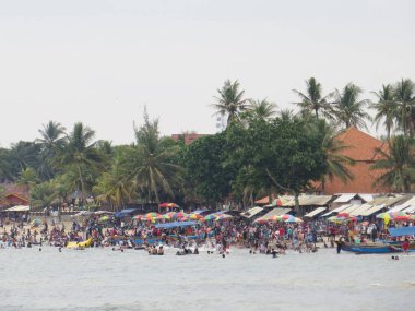 Anyer, Endonezya - 24 Haziran 2018: Kalabalık insan faaliyetleri Sambolo Plajı'nda yapıyor. Öğrencilerin uzun bir tatil gelince en yoğun Tatil Sezon Haziran ayıdır.