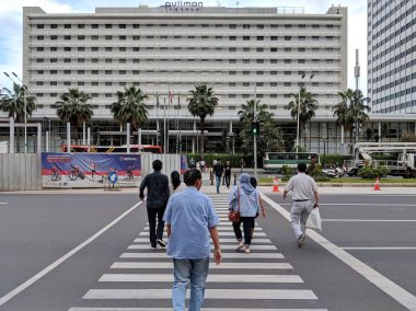 Jakarta, Endonezya-16 Şubat 2019: bazı insanlar Jalan Thamrin üzerinde Pelikan geçişi üzerinde yürüyüş.