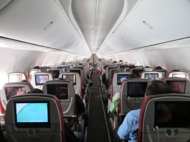 Jakarta, Endonezya - 17 Eylül 2019: Yolcularla dolu bir uçak kabininin arka görüntüsü.