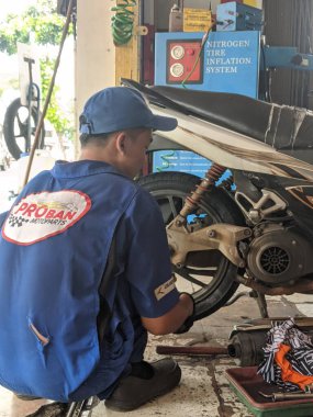 Tangerang, Endonezya - 22 Mayıs 2020: Bir tamirci Proban Motopart 'a motosiklet lastiği takıyor.