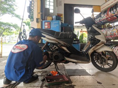 Tangerang, Endonezya - 22 Mayıs 2020: Bir tamirci Proban Motopart 'a motosiklet lastiği takıyor.