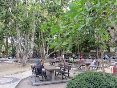 Denpasar, Endonezya - 28 Eylül 2019: Puputan Badung Meydanı 'nda park bankında oturan bazı insanlar.