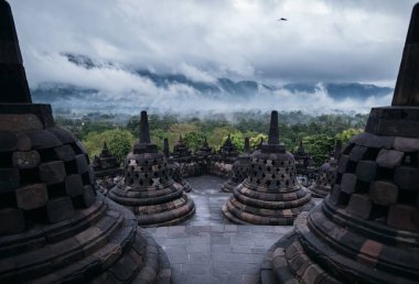 Borobudur Tapınağı ve yeşil orman yukarıda bulutlu gökyüzü stupas 