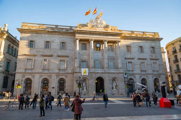 People walk in front of the Generalitat Palace of Catalonia in Sant Jaume square. The palace houses the offices of the Presidency of the Generalitat of Catalonia. — Stock Photo, Image