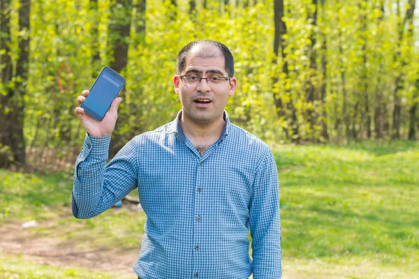 telefonda sürpriz orman arka planı olan adam