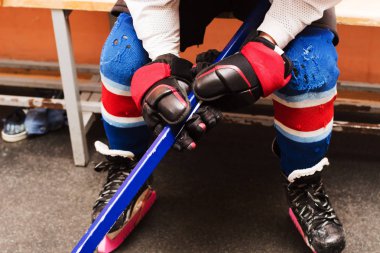 bacaklar bankta oturan bir hokey oyuncusu