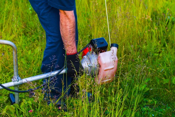 çim adam el ile çim biçme makinesi ile mows