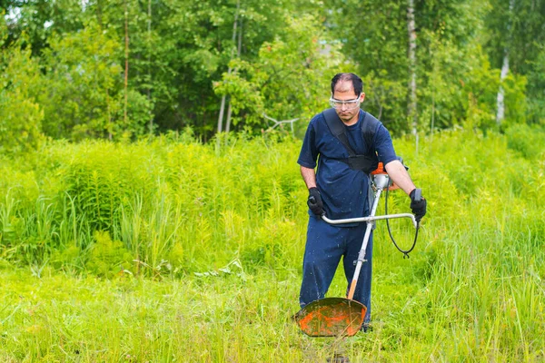 人工割草机割草坪的男子 — 图库照片